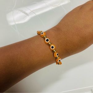 Orange and gold handmade evil eye bracelet meaning protection